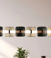 Modern wall-mounted light fixture with a plant in the foreground