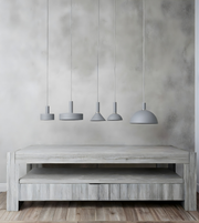 Wooden TV stand with four hanging pendant lights against a gray wall.