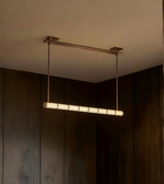 Modern pendant light hanging from a ceiling in a dimly lit room.