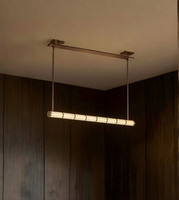 Modern pendant light hanging from a ceiling in a dimly lit room.