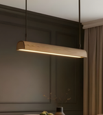 Modern pendant light hanging in a kitchen setting with neutral tones.