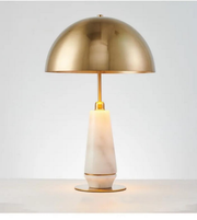 Gold table lamp with a white base on a light gray background