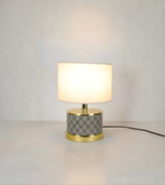 Table lamp with geometric patterned base on a plain background