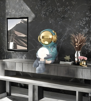 Decorative astronaut figure holding a light bulb on a shelf with a marble wall background.