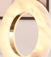 Gold circular light fixture on a neutral background