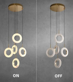 Pendant light with multiple circular rings, shown on and off, against a gray background.