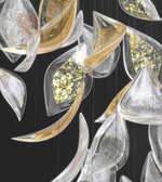 Decorative wall art with abstract leaf shapes in gold, silver, and clear on a black background
