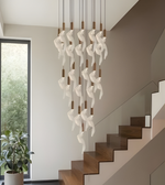 Modern chandelier hanging above a staircase with a window in the background