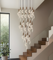 Modern chandelier hanging above a staircase with a window in the background