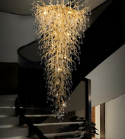Luxurious chandelier hanging in a modern interior setting with stairs.