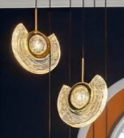 Gold earrings with a textured design on a dark background