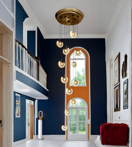 Modern interior design with a staircase, pendant lights, and a red chair.