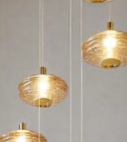 Gold pendant lights hanging against a plain background