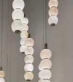 Chandelier with round, beige and white lampshades on a neutral background