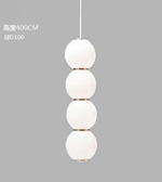 Modern pendant light with four spherical glass shades on a gray background