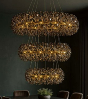 Decorative chandelier with multiple tiers hanging against a dark wall.