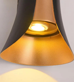 Close-up of a gold and black pendant light on a gray background