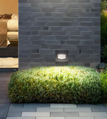 Outdoor garden light fixture on a brick wall with greenery
