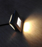 Small square light fixture on a wooden surface