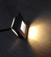 Small square light fixture on a wooden surface
