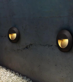Two round outdoor lights embedded in a concrete wall.