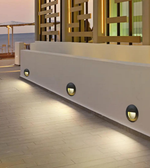 Modern outdoor setting with a white wall and decorative metal grid, featuring wall-mounted lights.