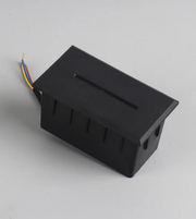 Black electronic component with wires on a gray background