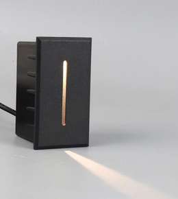 Black outdoor light fixture with a horizontal copper accent on a gray background