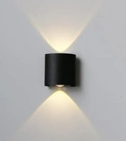 Black wall-mounted light fixture on a gray wall