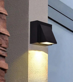Black outdoor wall light fixture on a textured wall