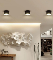 Modern interior design with ceiling lights, abstract wall sculpture, and decor items.