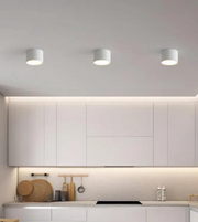 Modern kitchen with white cabinets, a backsplash, and three ceiling lights.