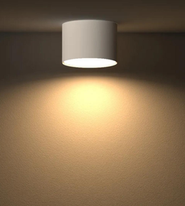 White cylindrical ceiling light fixture on a beige wall.