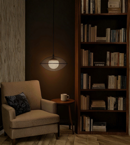 Cozy reading nook with armchair, bookshelf, and pendant light.