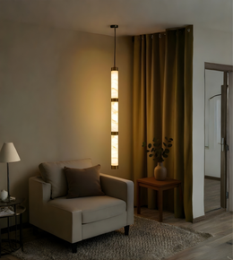Modern living room with a beige armchair, pendant light, and decorative elements.