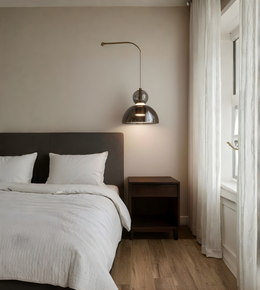 Modern bedroom with a bed, nightstand, and pendant light.