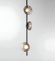 Modern pendant light with three glass shades on a white background