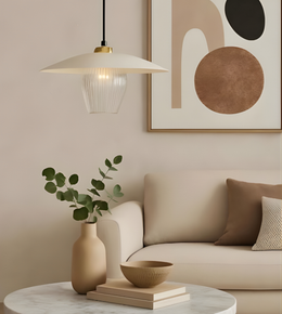 Modern living room with a beige sofa, pendant light, abstract art, and decorative items.