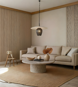 Modern living room with beige sofa, round stone coffee table, and decorative elements.