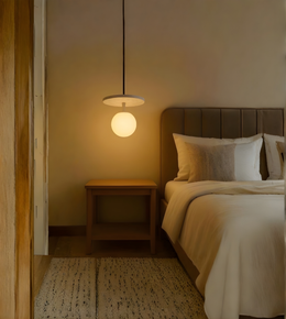 Bedroom with a bed, nightstand, and pendant light.