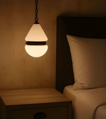 Light bulb hanging above a bed in a dimly lit room