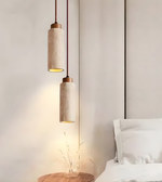 Two pendant lights hanging above a bed in a bedroom setting.