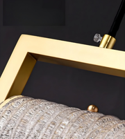 Close-up of a gold-framed lamp with crystal shade against a dark background