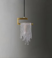 Modern pendant light with gold fixture and glass shade on a gray background