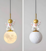 Two pendant lights with astronaut designs on a plain background