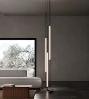 Modern floor lamp in a minimalistic living room with a sofa and window view.