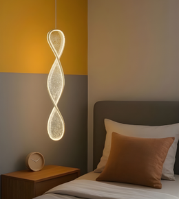 Modern pendant light hanging above a bed in a bedroom with warm lighting.