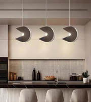Modern kitchen with three hanging pendant lights above a countertop.