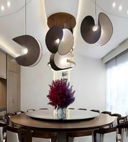 Modern dining room with round table, chairs, and stylish ceiling lights.