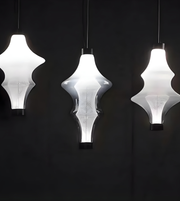 Three modern pendant lights with white glass shades on a black background
